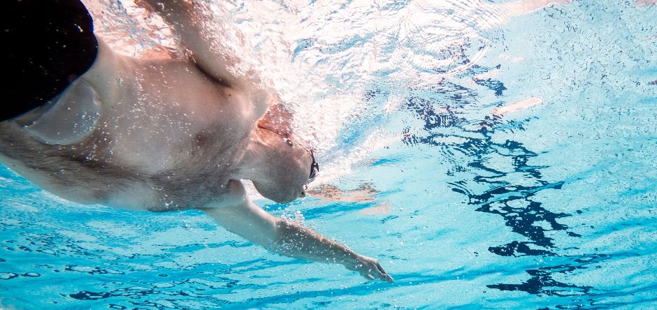 Άντρας που κολυμπάει σε πισίνα με σάκο κολοστομίας