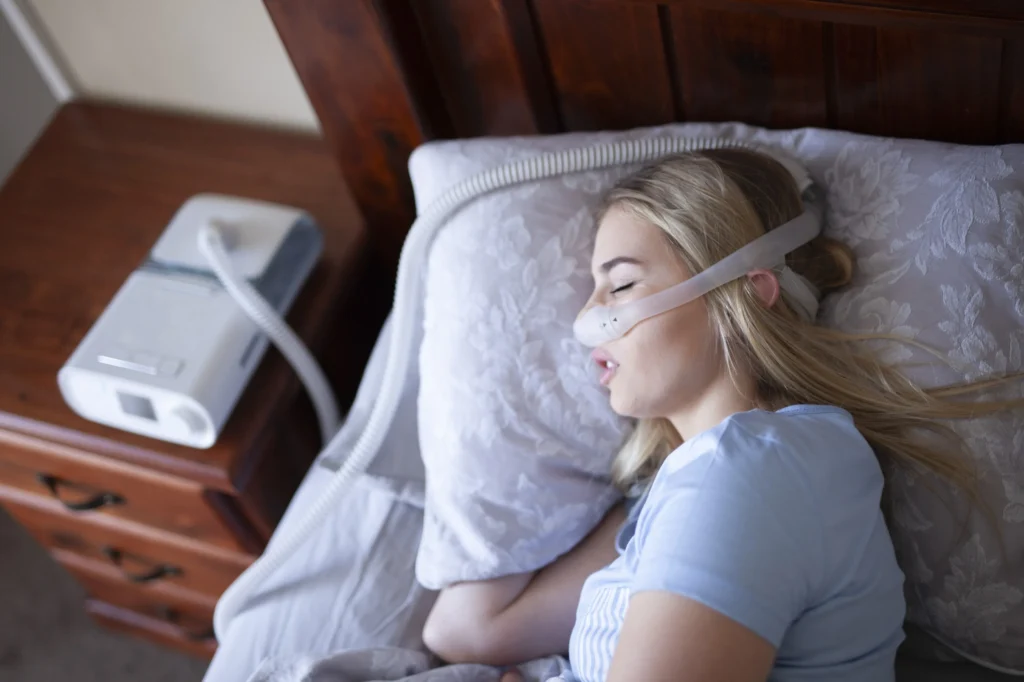 Κοπέλα που κοιμάται με CPAP συσκευή επειδή έχει υπνική άπνοια